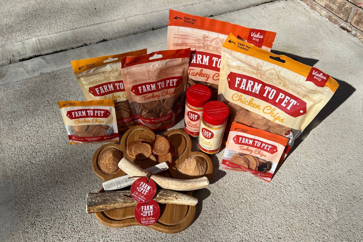 Farm to Pet Dog Treat, Chews, and Toppers Collection displayed on a  paw board.