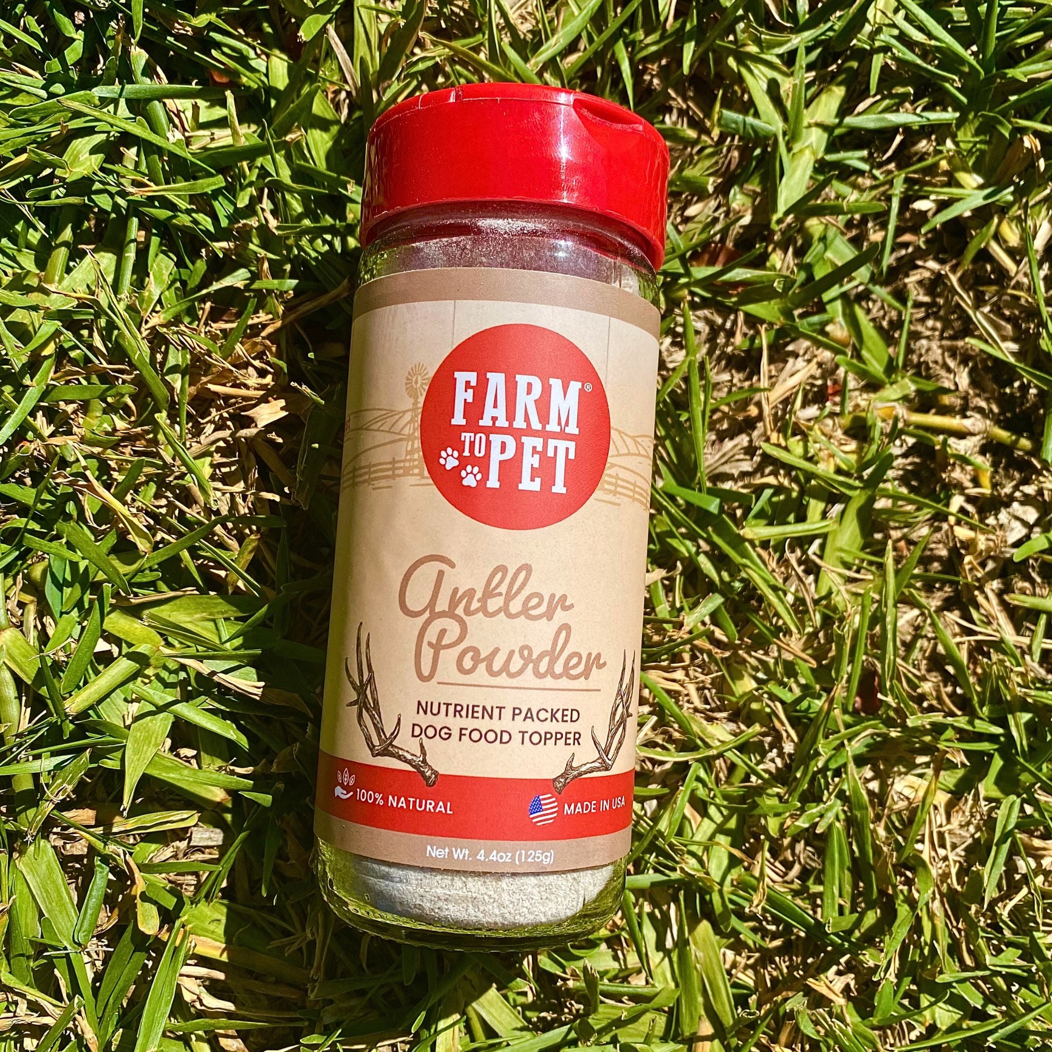 Product Picture of Farm to Pet Elk Antler Powder Dog Food Toppers in an outdoors on green grass.