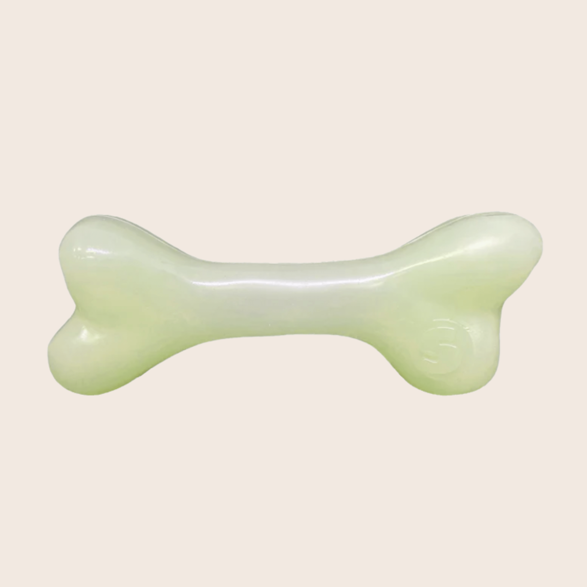 GLOW IN THE DAR bone-shaped object on a beige background FROM FARM TO PET