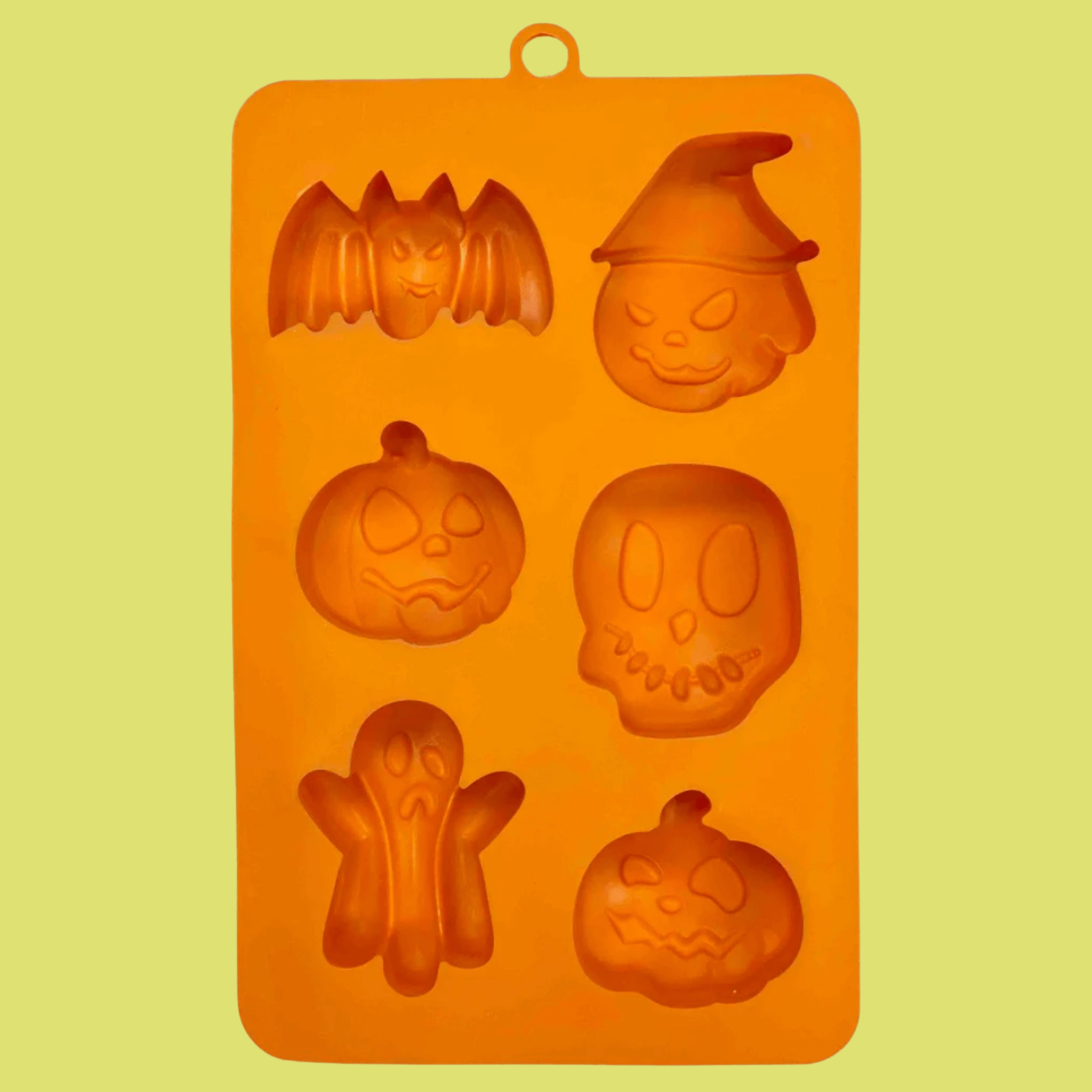 Farm to Pet  Halloween Pet Treat Mold in Orange silicone with Halloween-themed shapes on a yellow background front of mold.