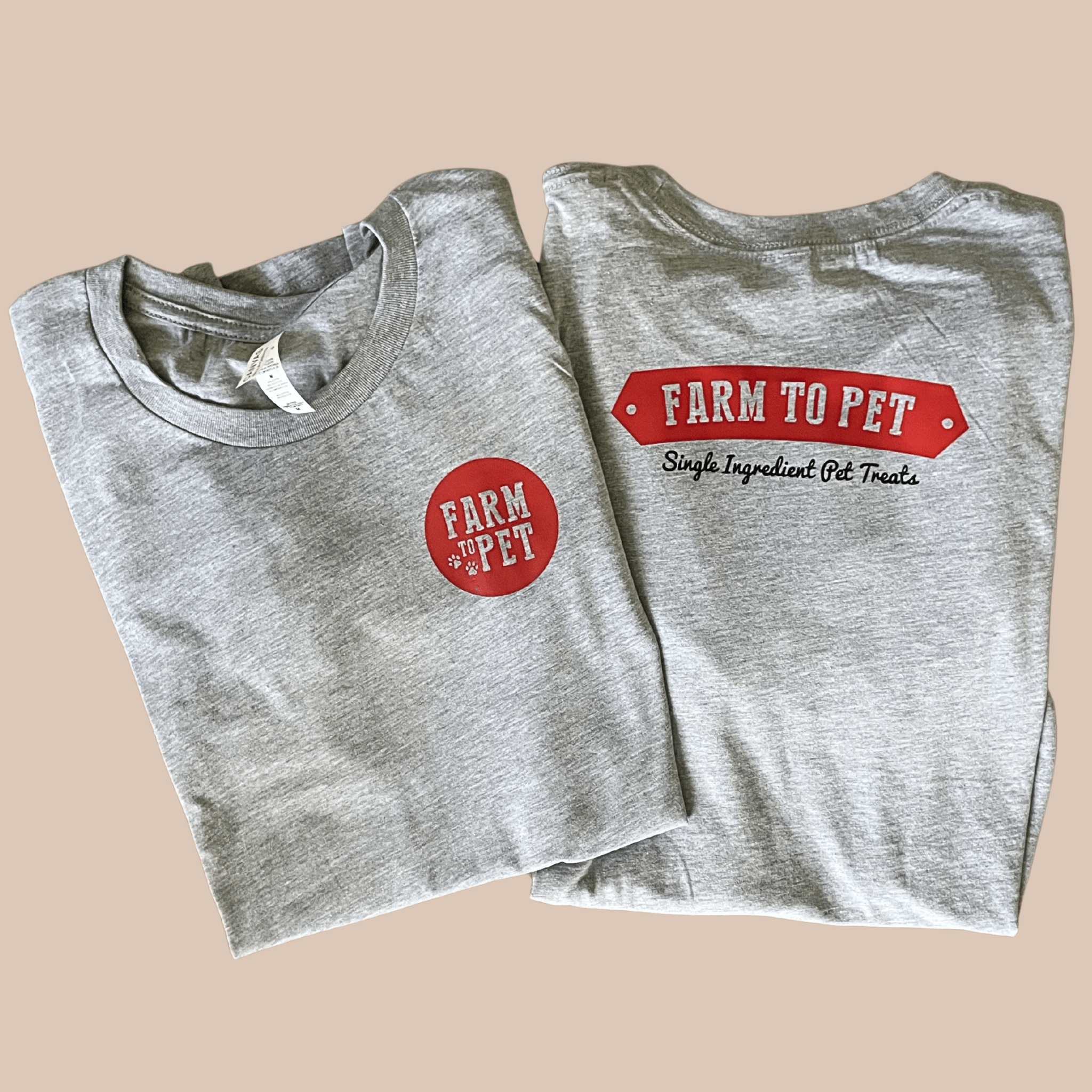 Two folded gray t-shirts showing the front and back with Farm to Pet branding on a beige background.