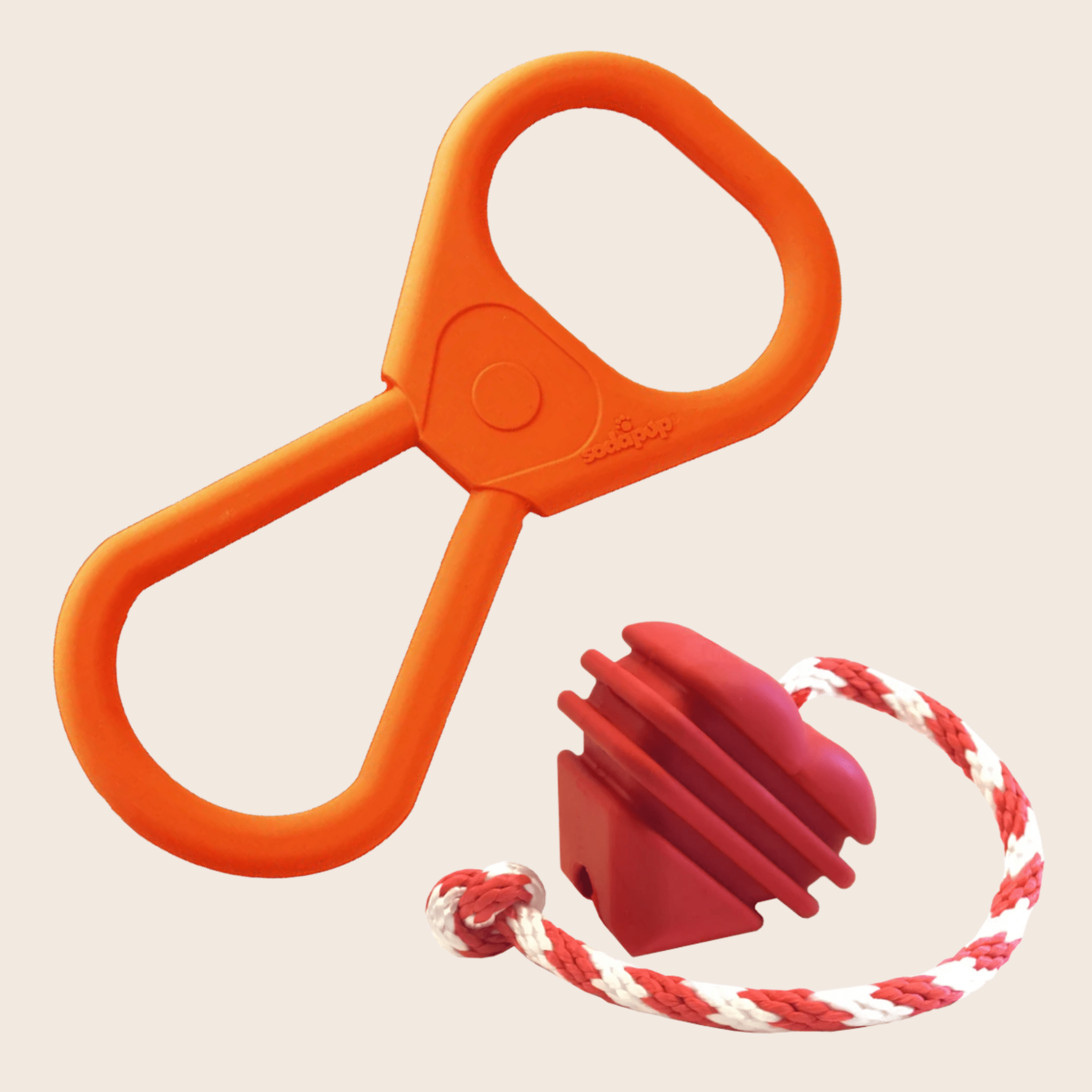 Farm to Pet Tug Toys Pop Top Tug is Orange plastic Tug and Heart On a String Tug with a red and white rope attachment on a beige background.
