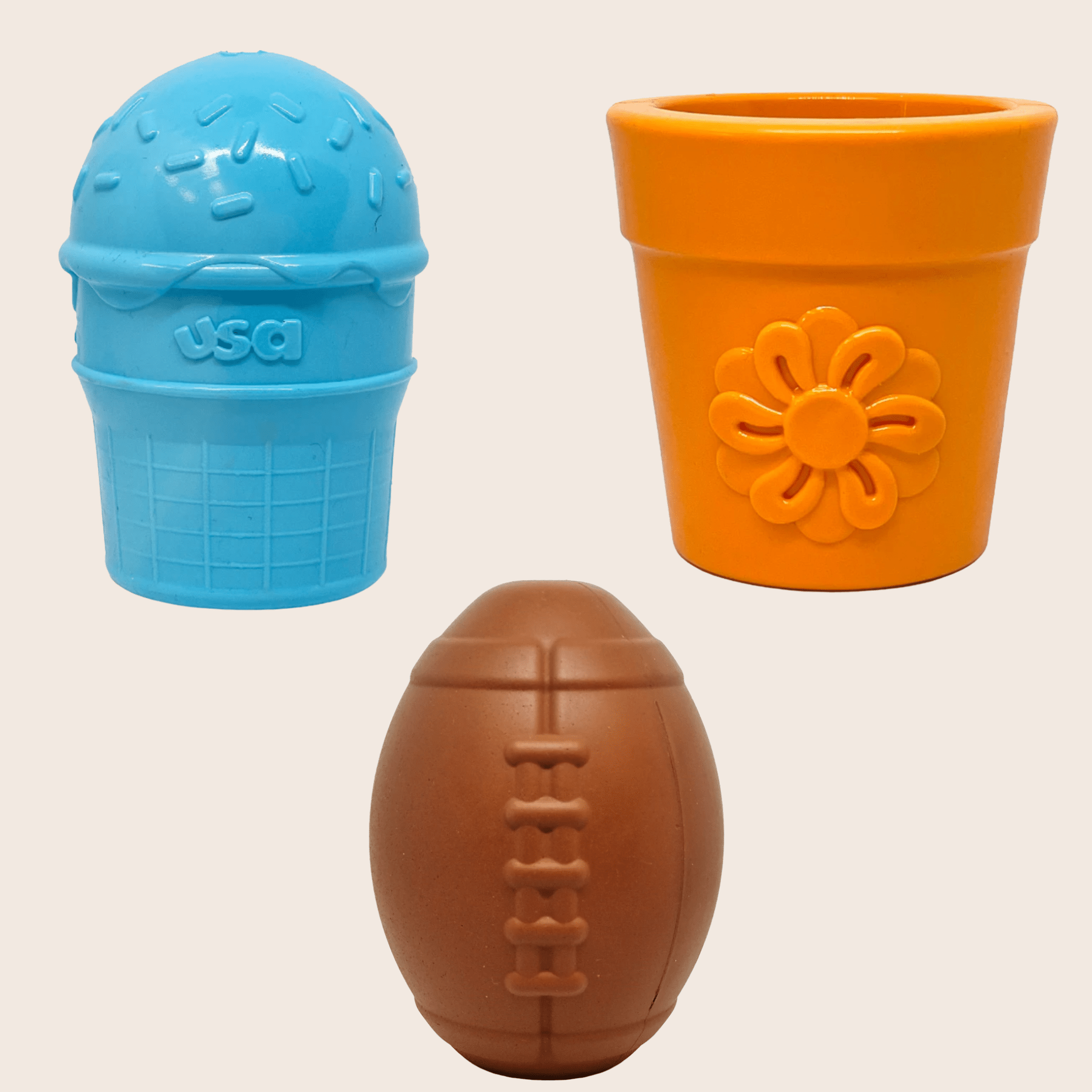 Three colorful Farm to Pet Dog Treat Dispensers blue ice cream, orange flower pot and brown football on a beige background
