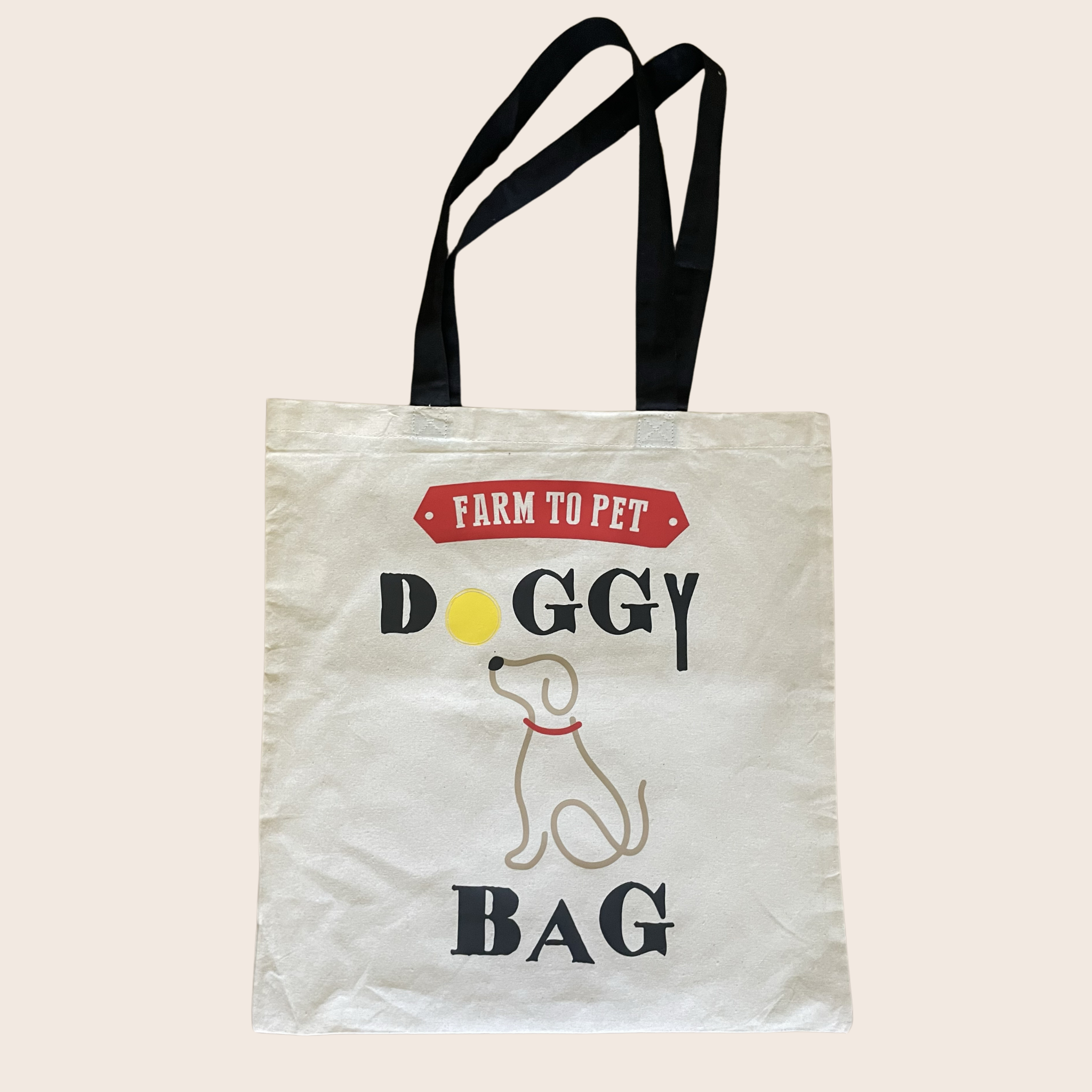 A white and black tote bag with Farm to Pet Doggy Bag text and a dog illustration on a beige background.