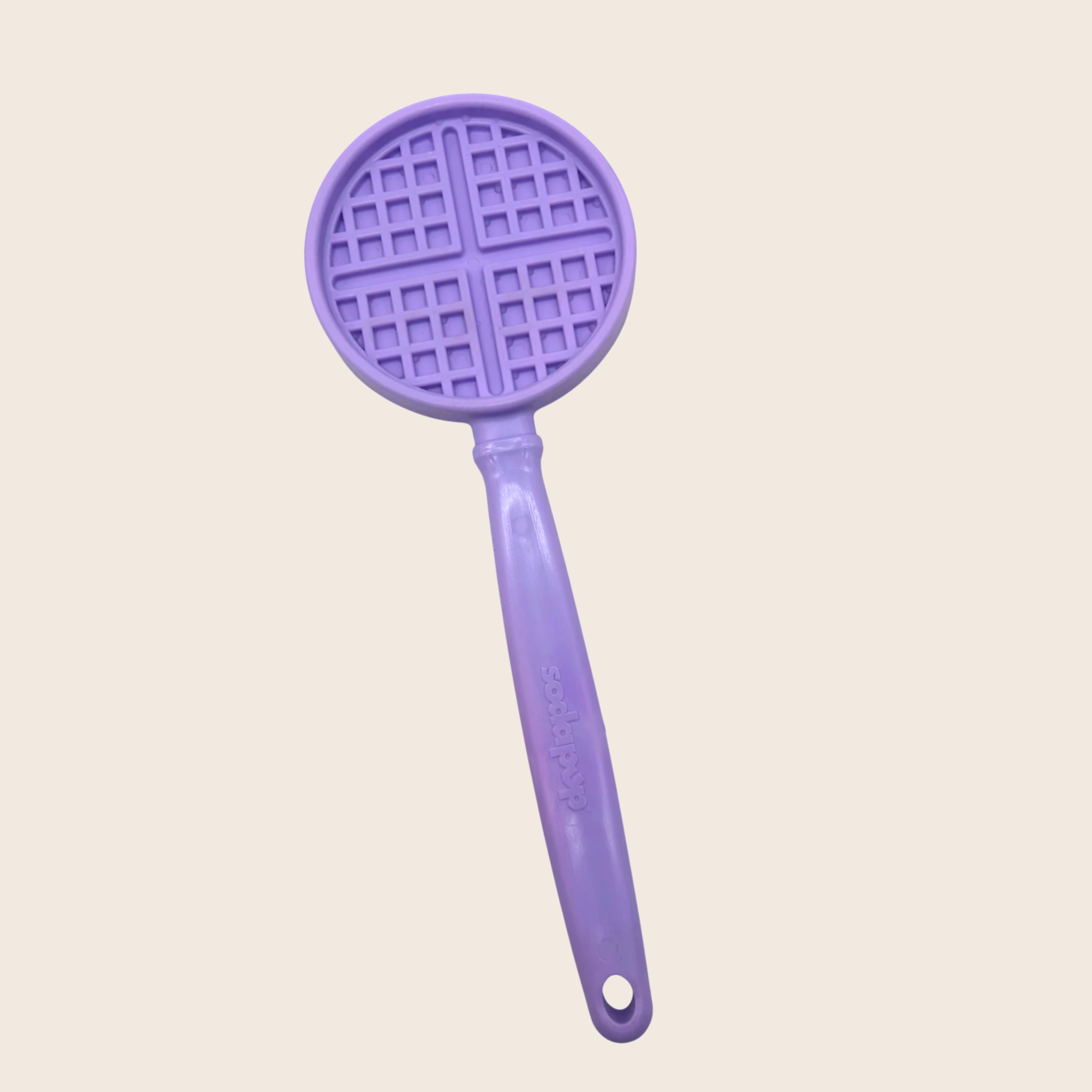 Purple waffle-patterned lick stick for dogs on a light beige background