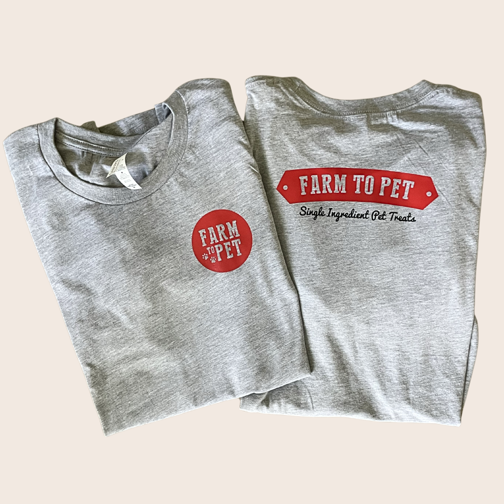 Two folded gray t-shirts showing the front and back with Farm to Pet branding on a beige background.