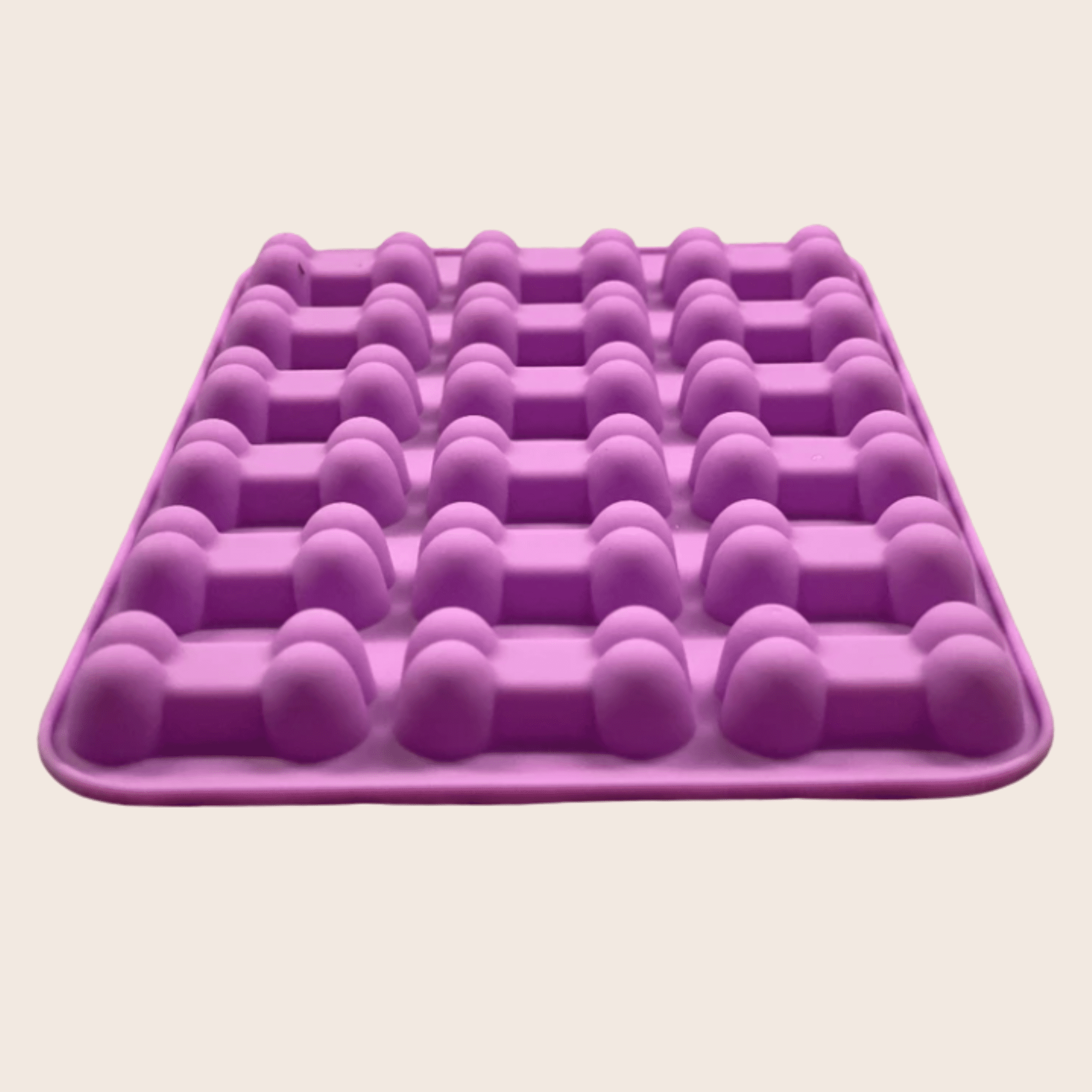 Purple silicone mold with multiple compartments on a beige background