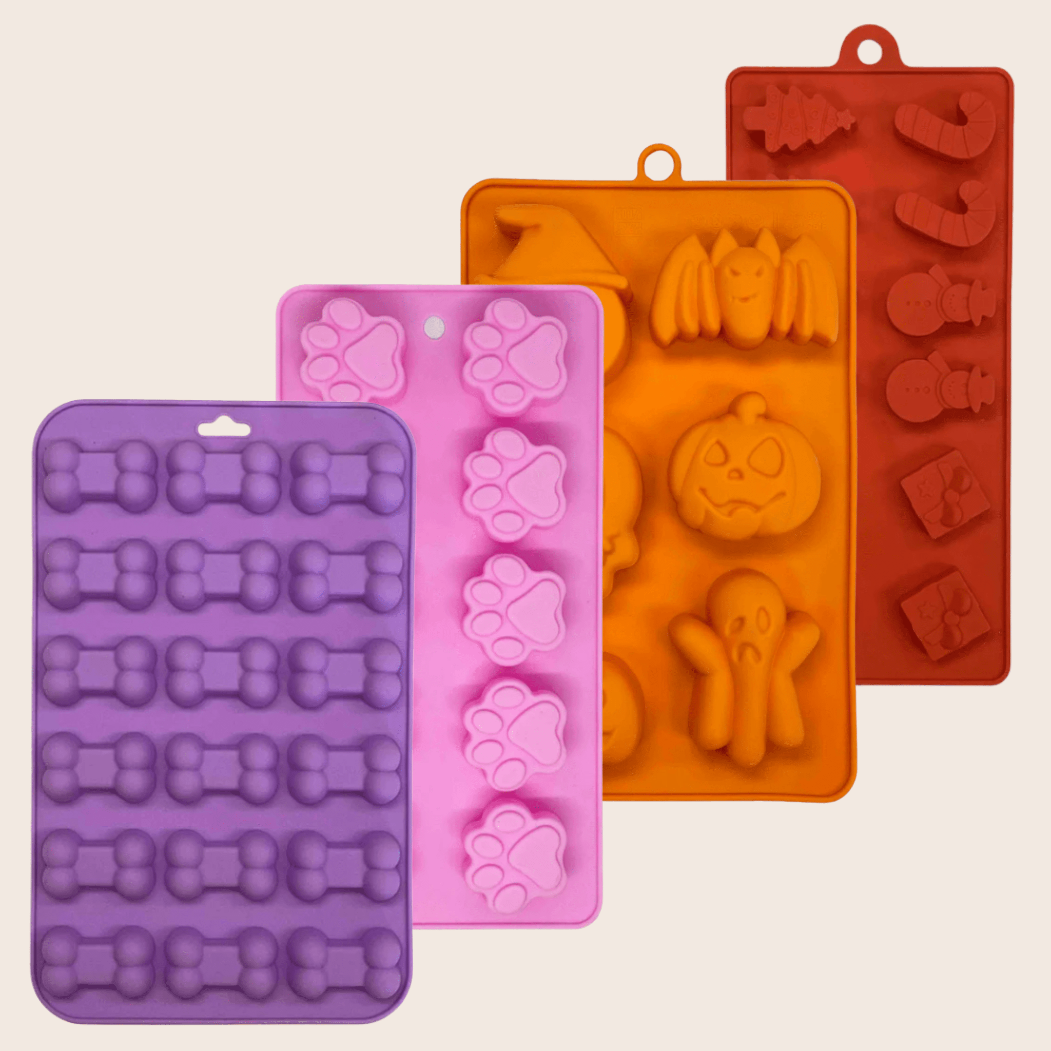 Set of four colorful silicone molds with various shapes on a beige background