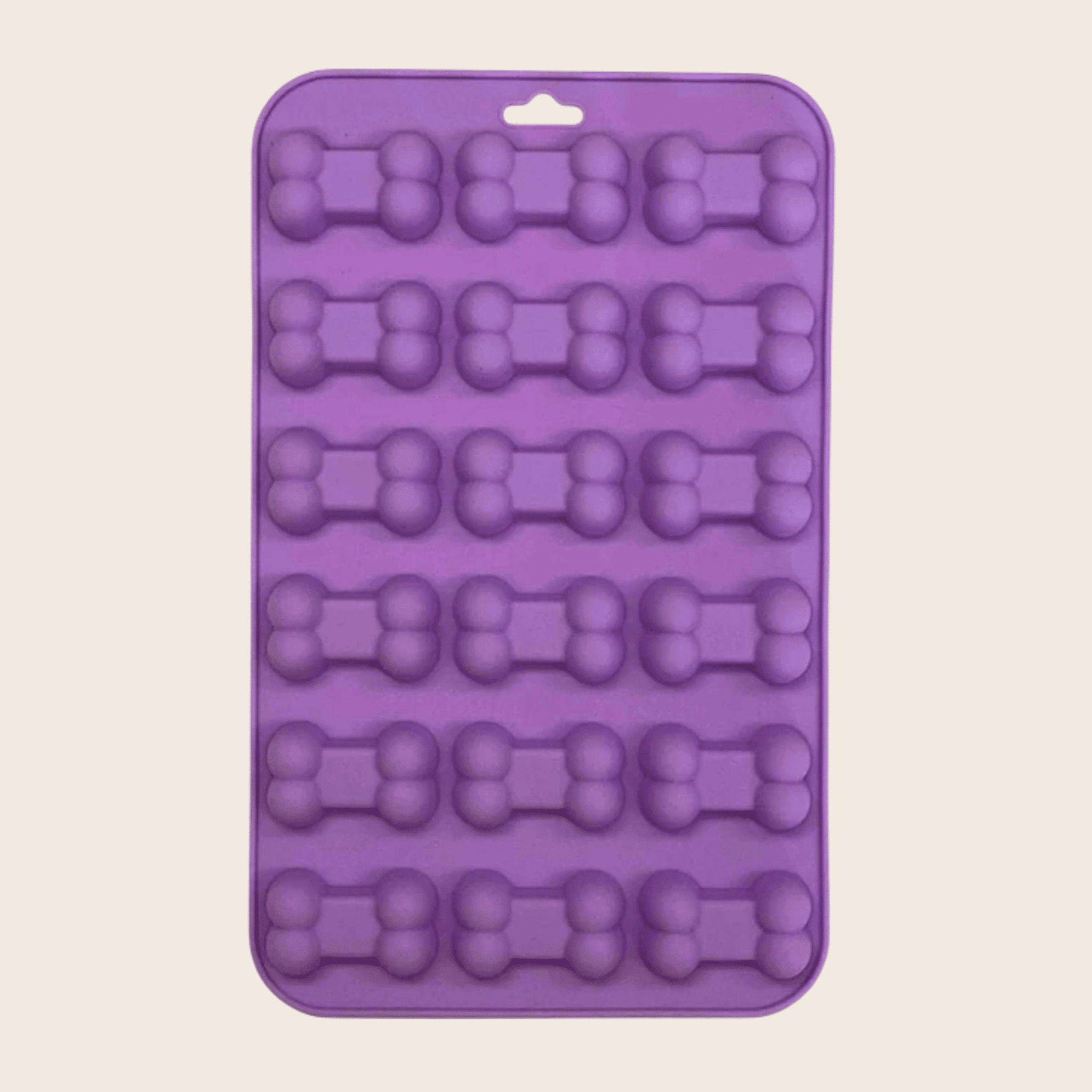 Purple silicone mold with bone-shaped cavities on a beige background