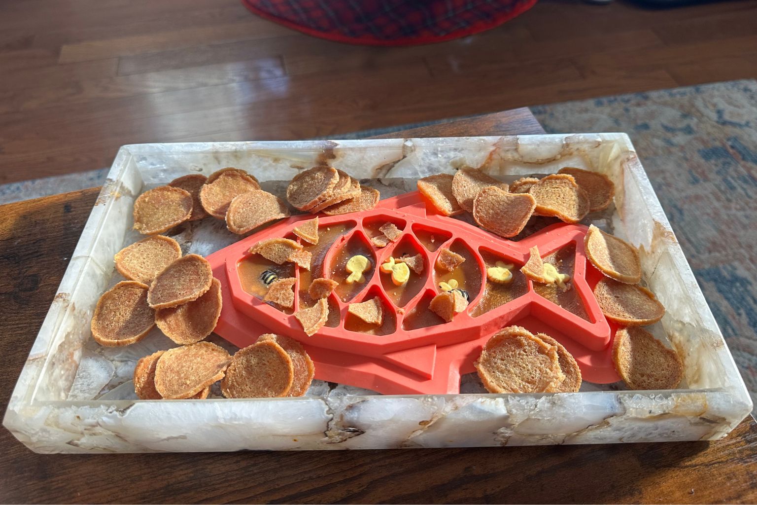a tray of Farm to Pet fish chips dog treats and a fish shaped lick mat
