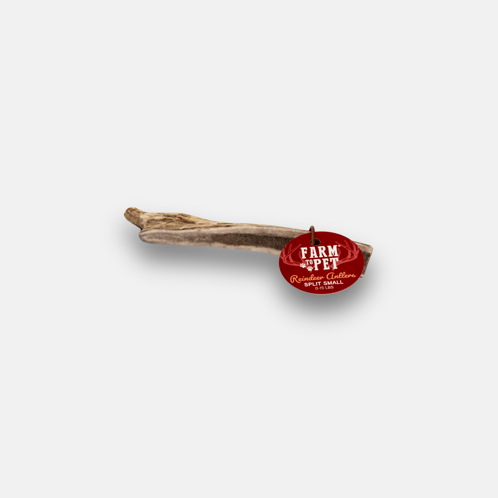 Red round label with text on a Farm to Pet reindeer antler against a white background.
