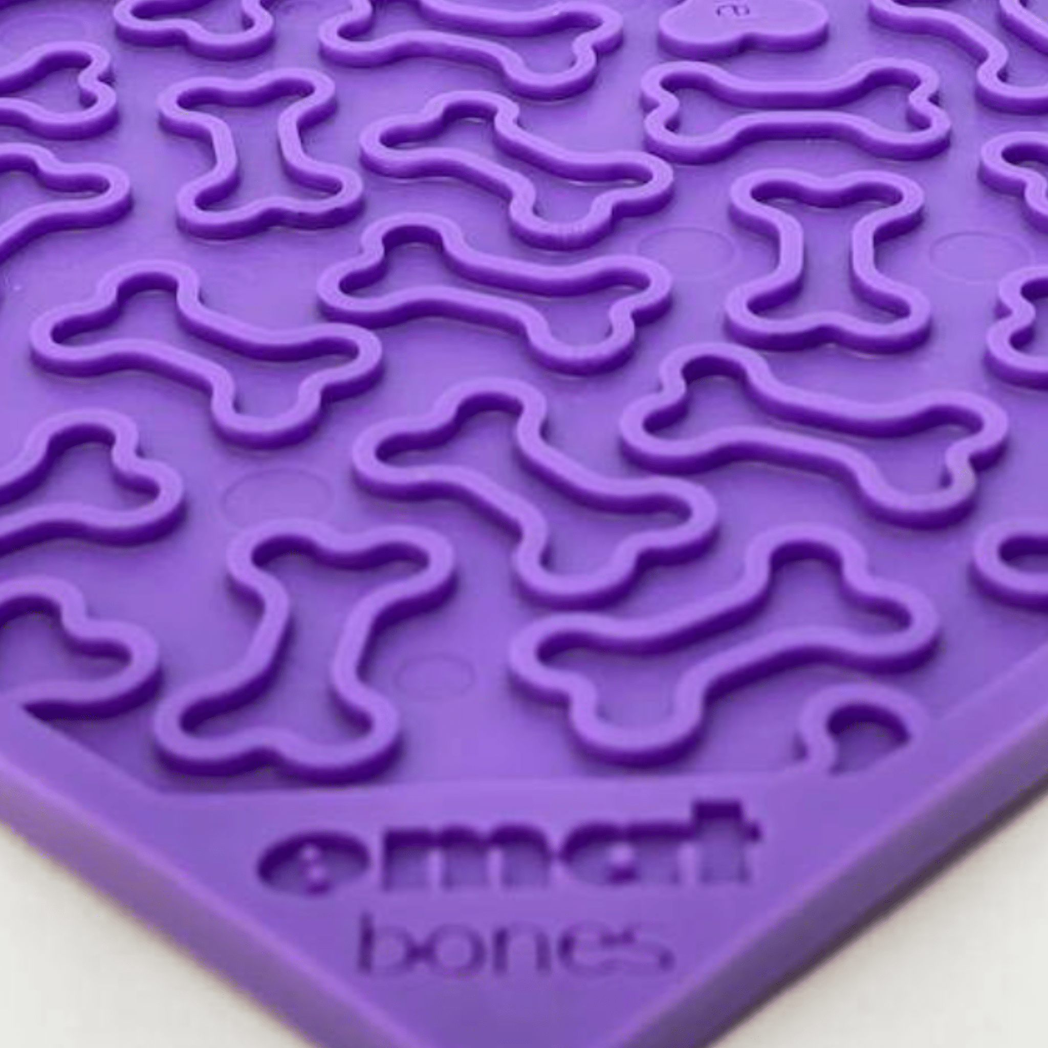 Farm to Pet Purple silicone lick mat with bone shapes on a white background.