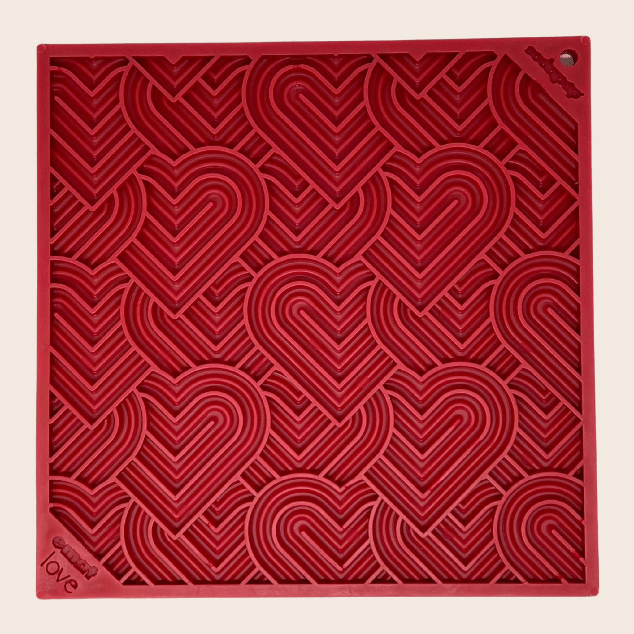 Farm to Pet Red Heart lick mat  textured square with heart patterns on a beige background.
