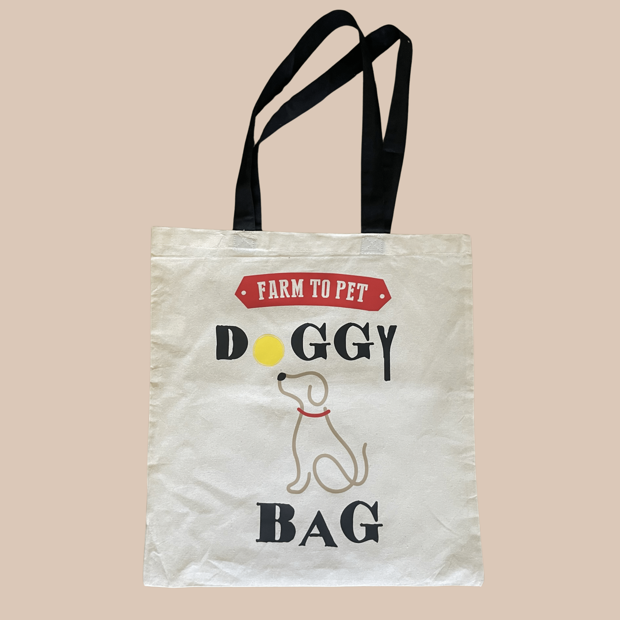 A white and black tote bag with Farm to Pet Doggy Bag text and a dog illustration on a beige background.