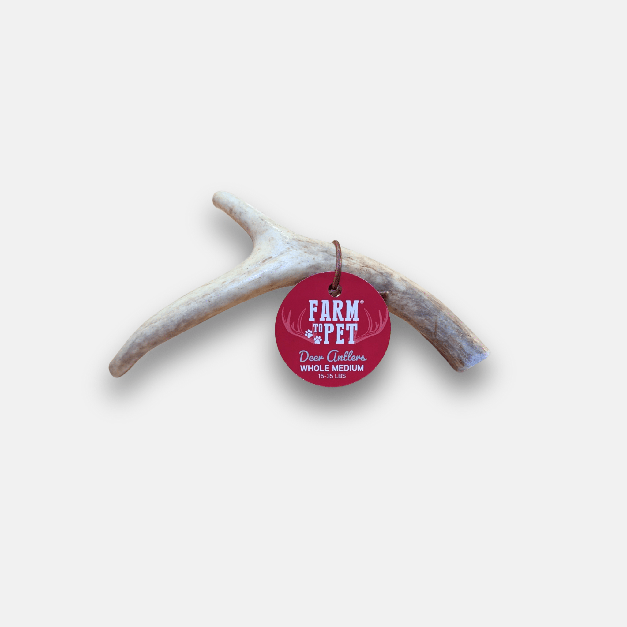 Farm to Pet red round tag with text on a deer antler against a white background.