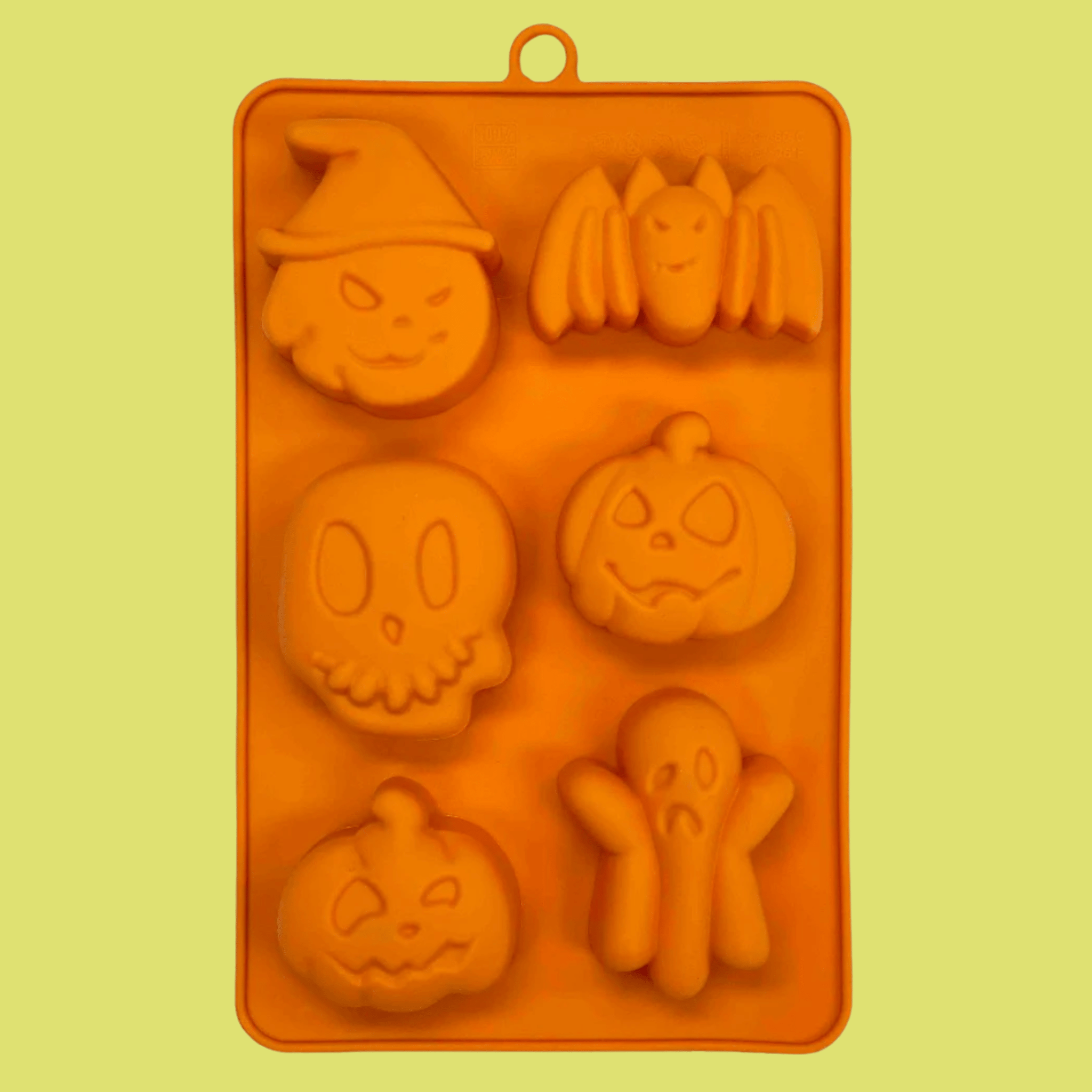 Farm to Pet Halloween Pet Treat Mold  made of Orange silicone with Halloween-themed shapes on a yellow background back of mold.
