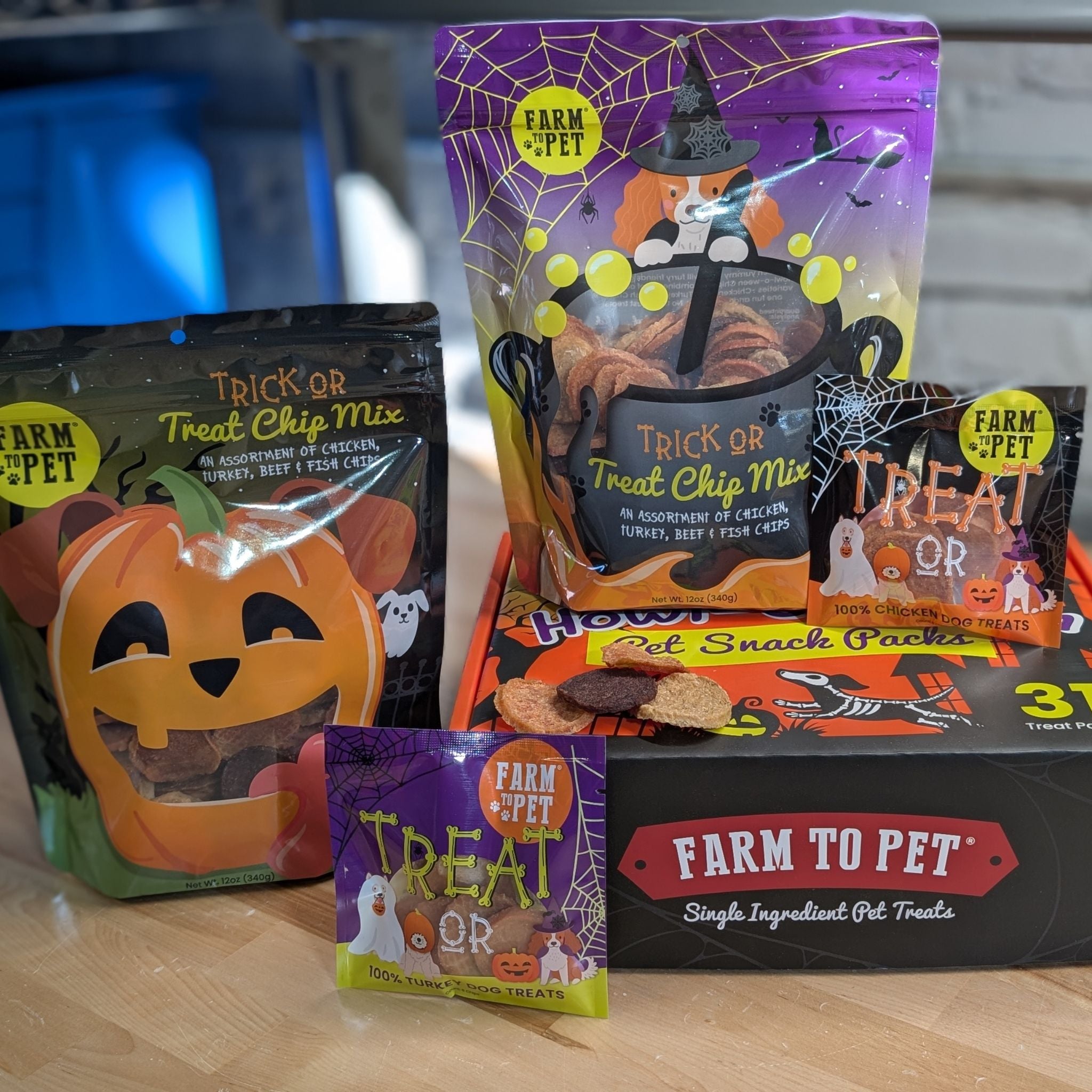 Farm to Pet Halloween-themed pet treat packages on a wooden surface.
