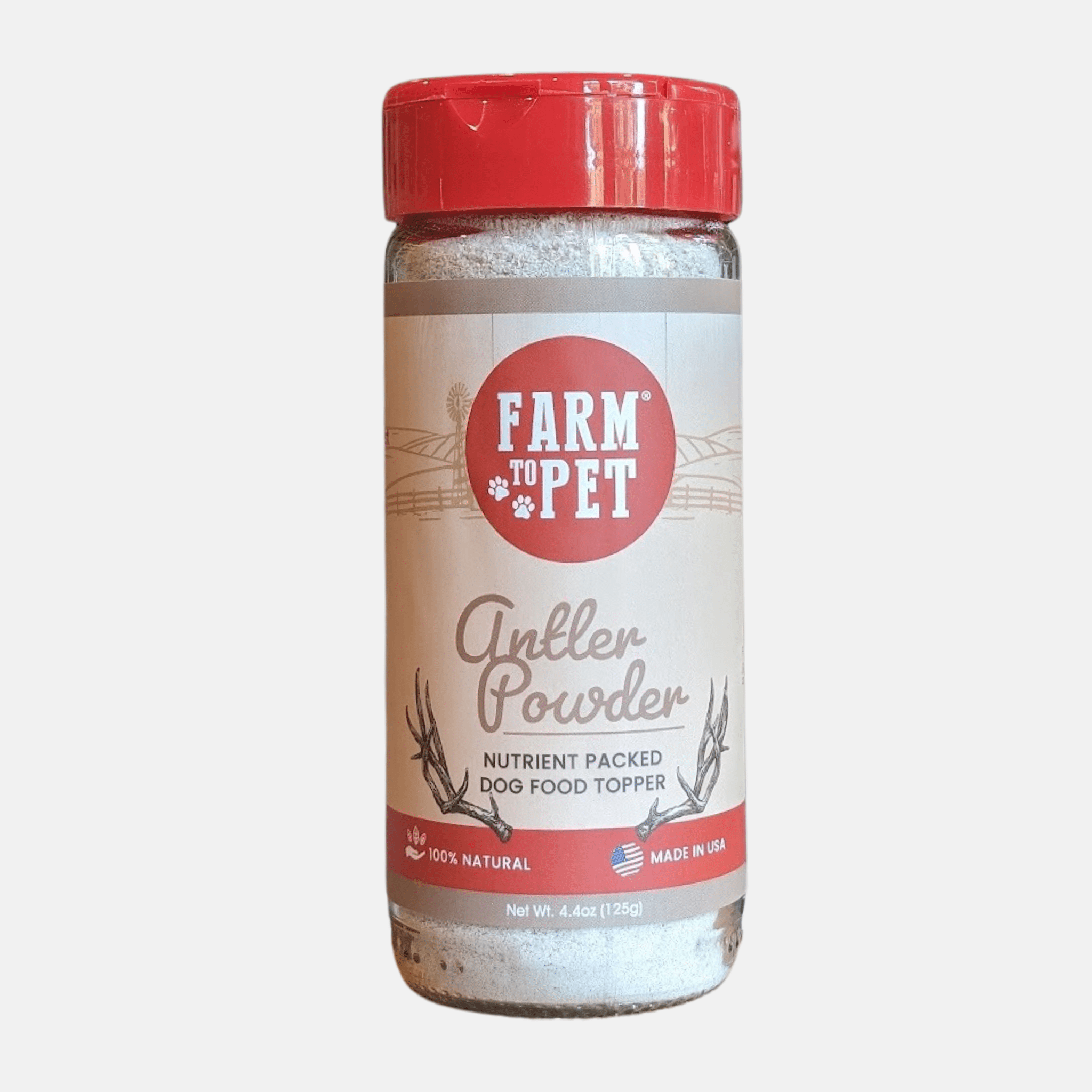 The front of a jar of Farm to Pet Antler Powder with a red lid on a cream background.