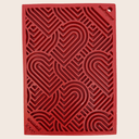 A Farm to Pet Red Hearts Lick Mat  textured with heart pattern on a beige background.
