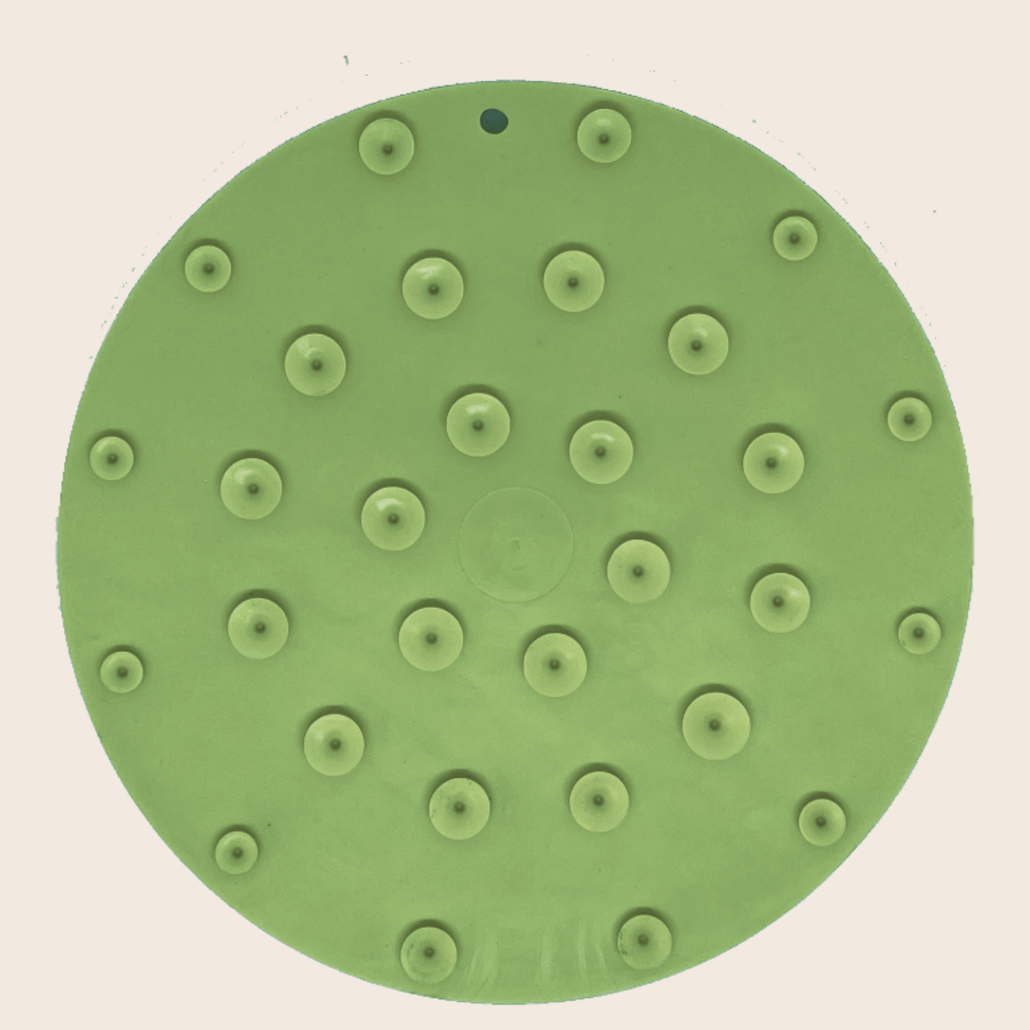 A Farm to Pet Green Camp Lick Mat showing suction cups on the back on a beige background.