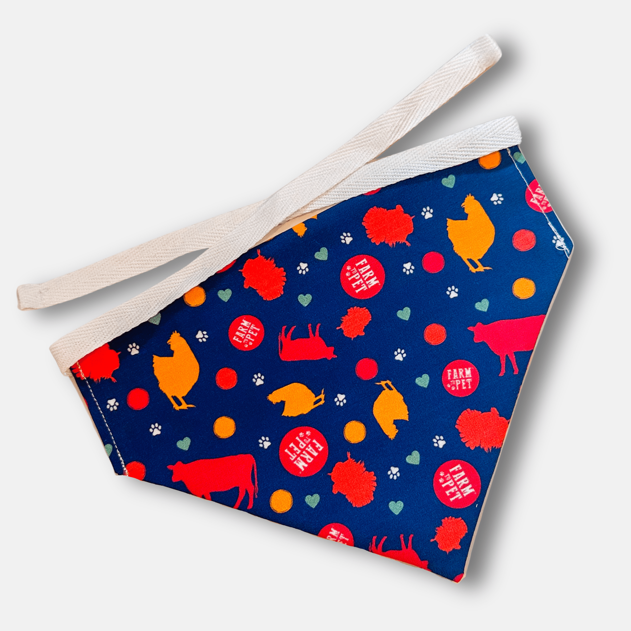 Fabric dog bandana from Farm to Pet with farm animal pattern on a blue background, featuring cows, chickens, and pigs.