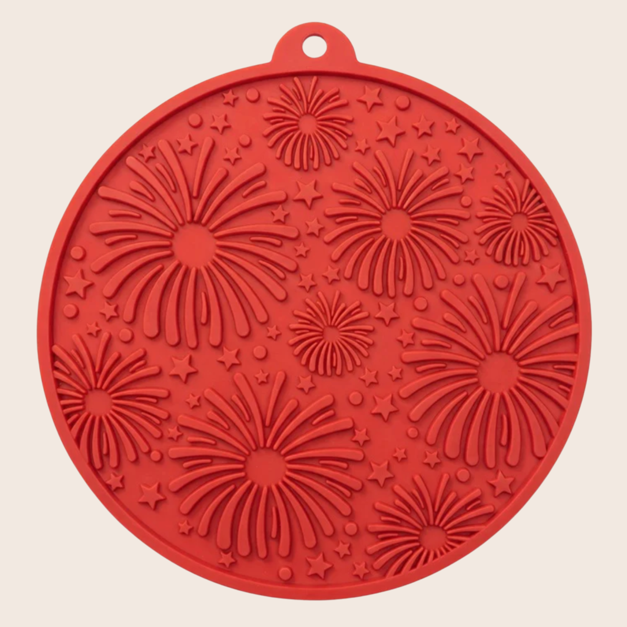 Red silicone lick mat with firework pattern on a beige background