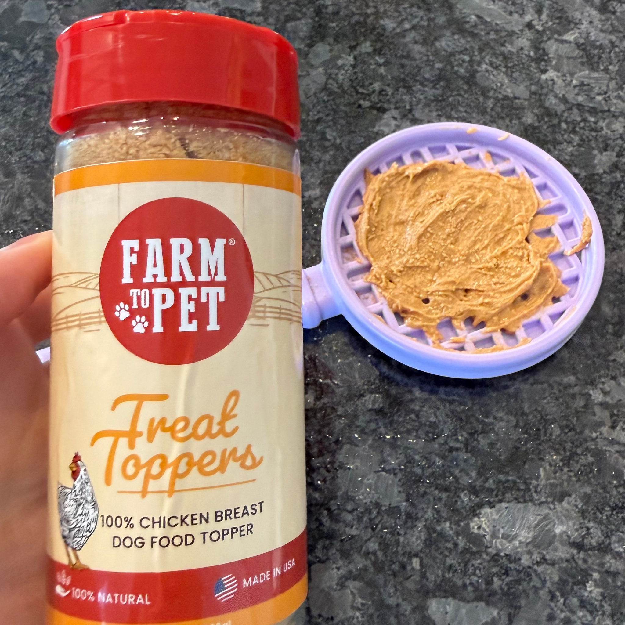 Farm to Pet Treat Toppers jar with waffle lick stick on a gray surface