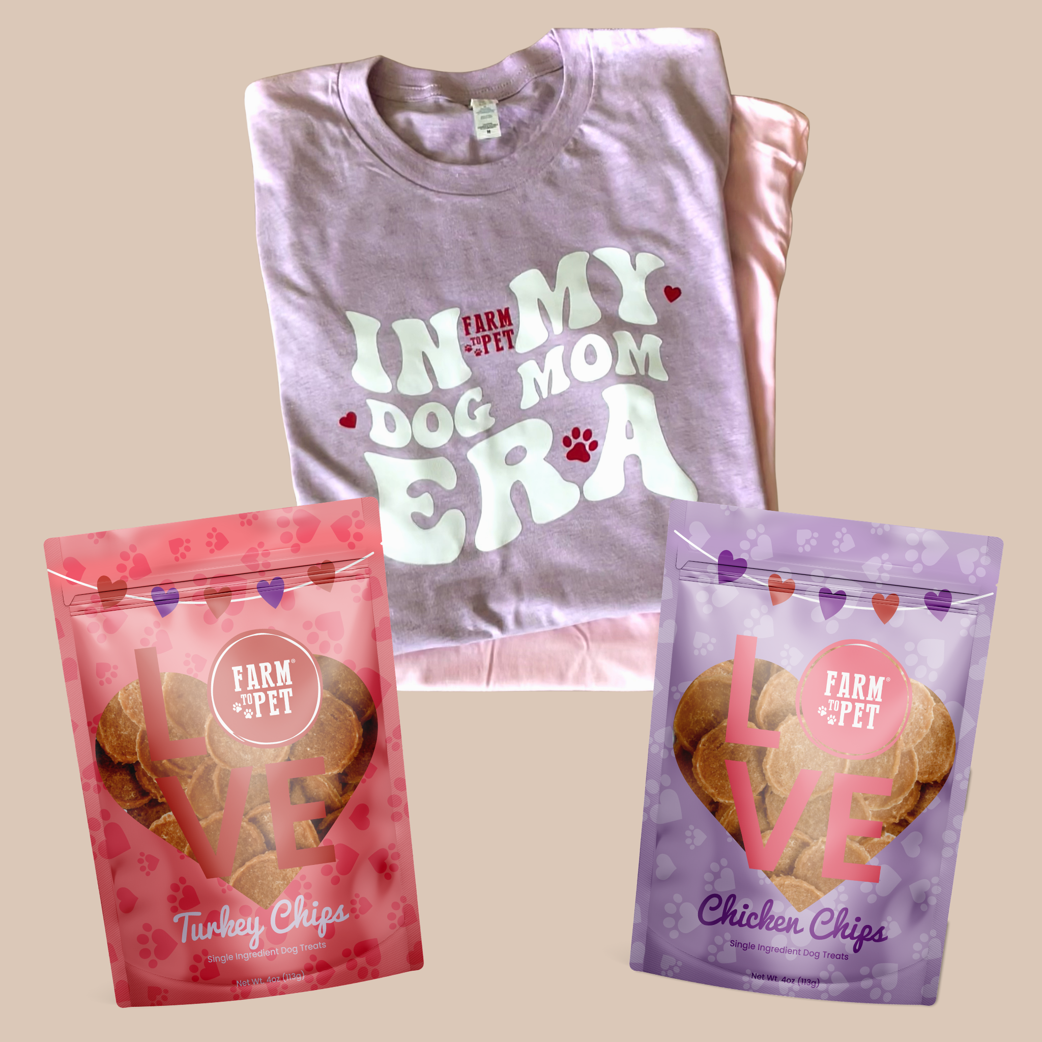 Folded t-shirt with 'In My Dog Mom Era' text and two bags of dog treats on a beige background