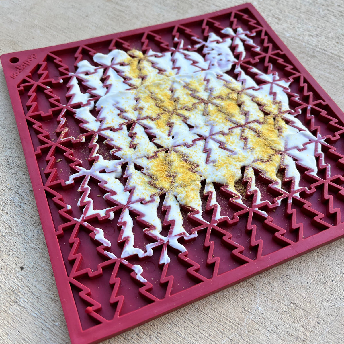 Holiday Red Tree lick mat topped with yogurt and Antler Powder, an enrichment dog treat idea